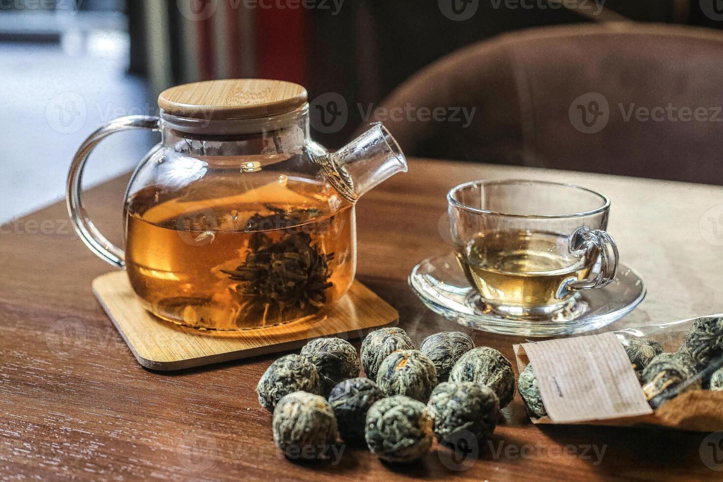 glas te pott fylld med grön te Nästa till en kopp av te foto