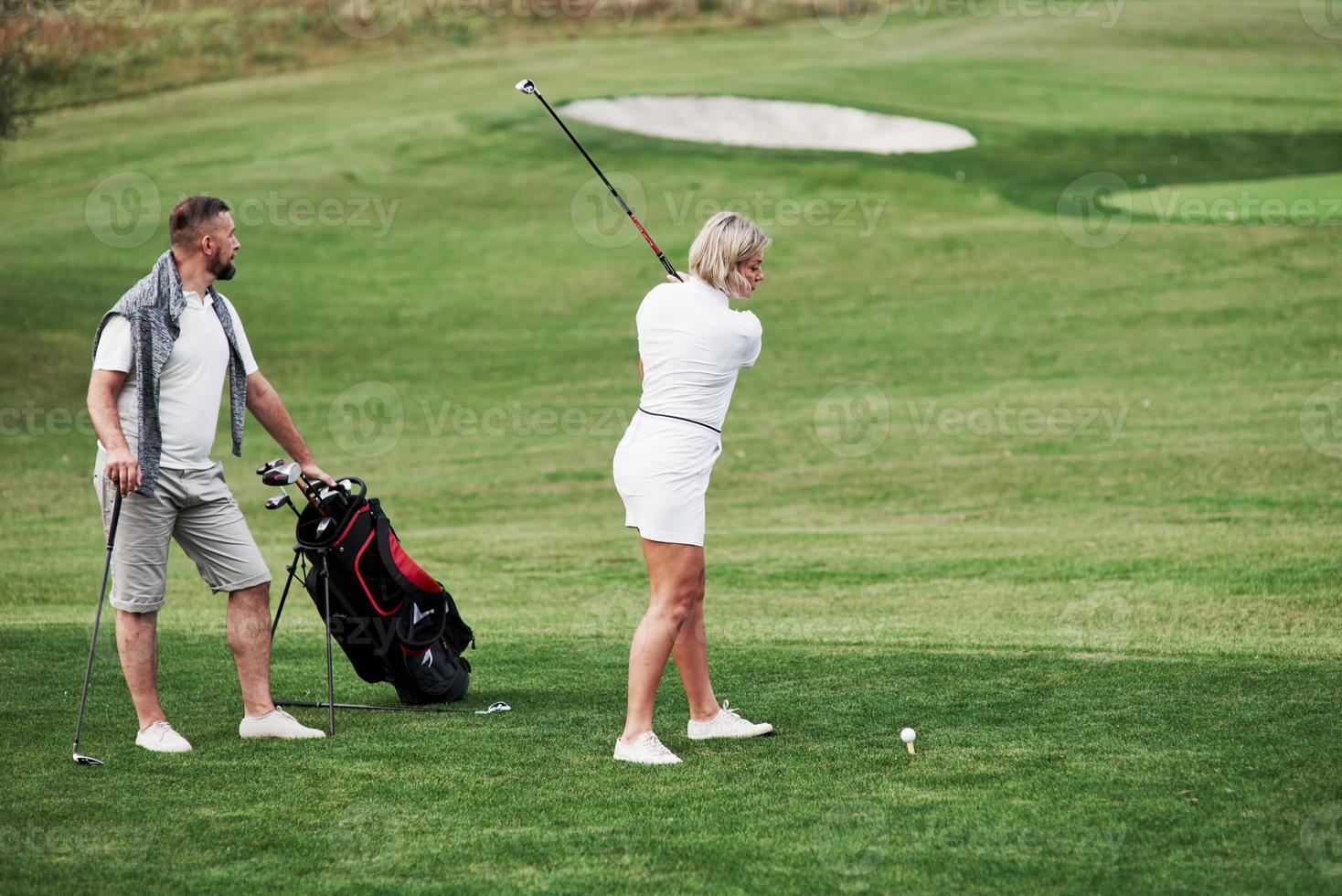 försöker slå bollen. ett par golfspelare har bra spel under helgen foto