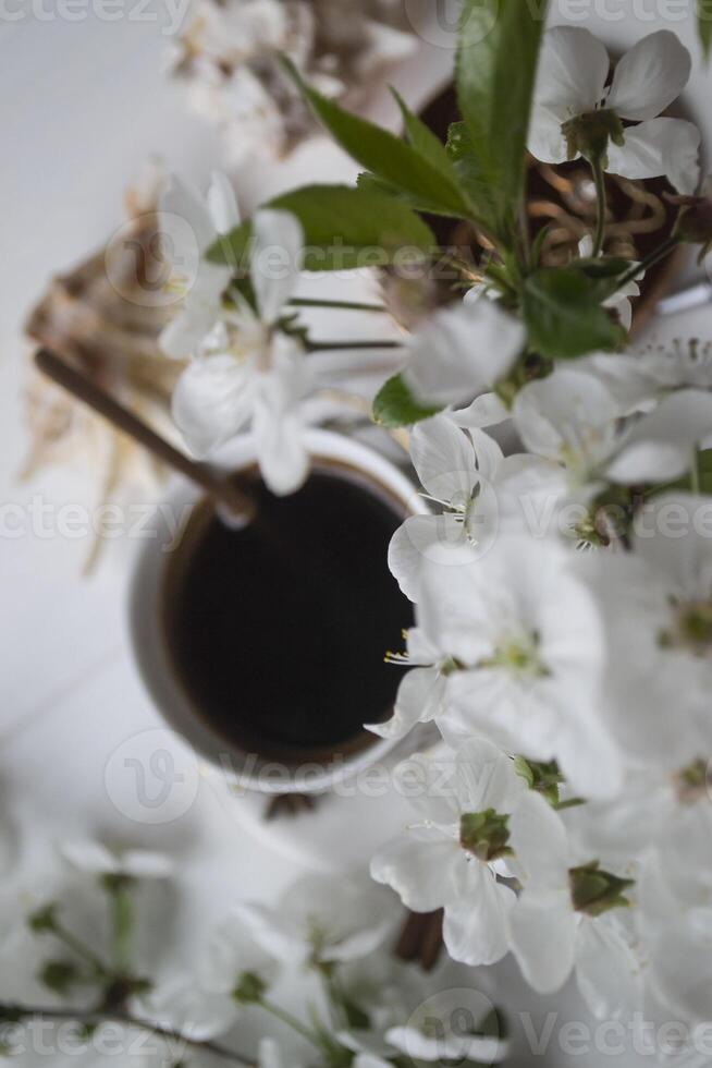 en kopp av kaffe och blomma grenar. vår morgon. foto