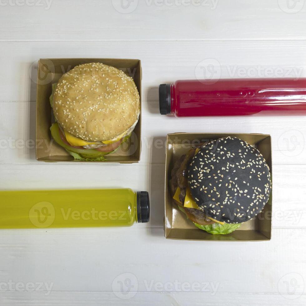 vit och svart burger med juice på de tabell. foto