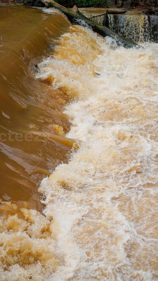 den utseende stänga till de avledning av mulen vatten den där flöden snabbt bortom de gräns damm. foto