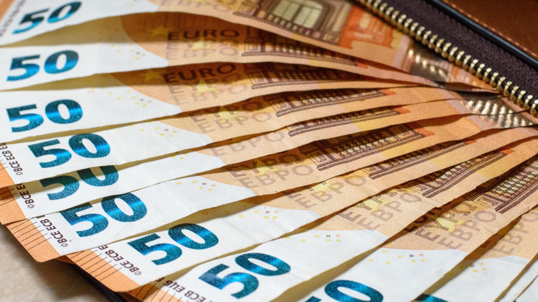 femtio euro sedlar i en brun handväska lagd fläkt. närbild. selektiv fokus foto