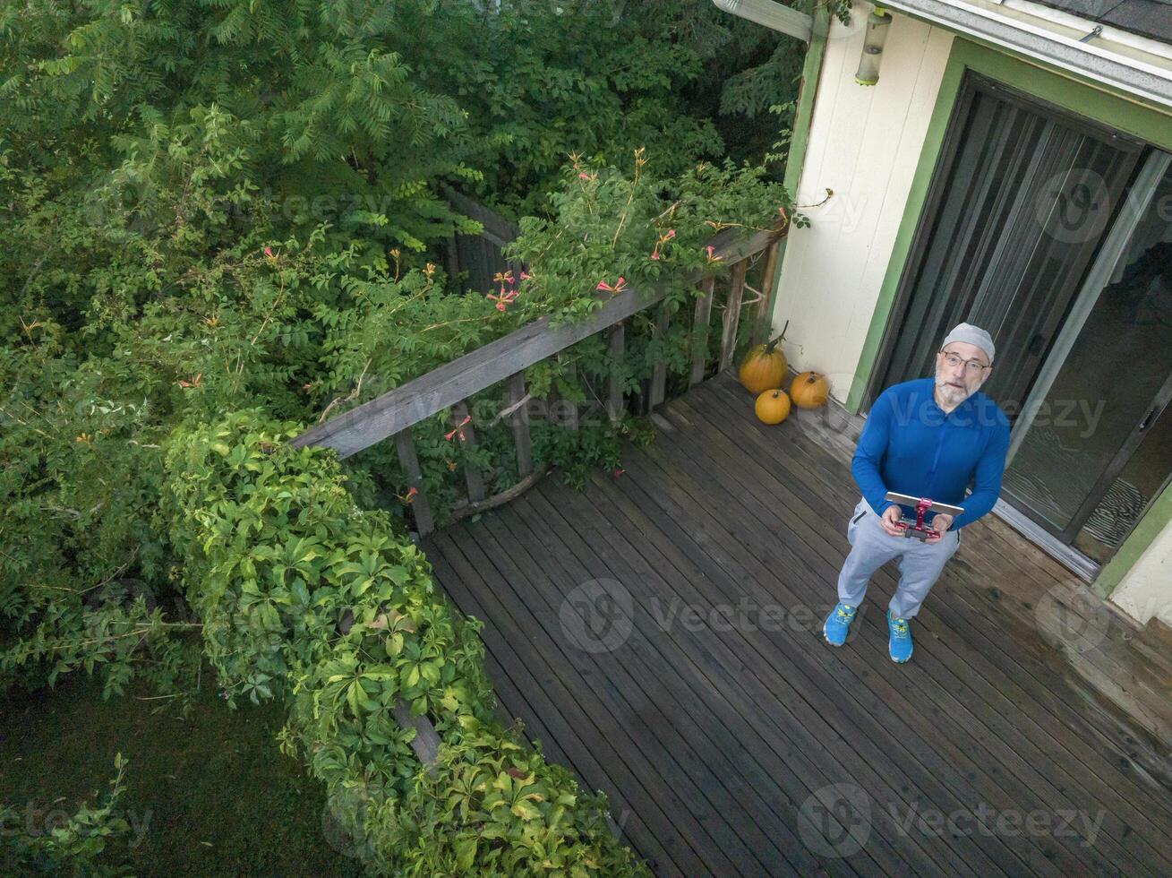 senior man med en Drönare radio kontrollant och läsplatta foto