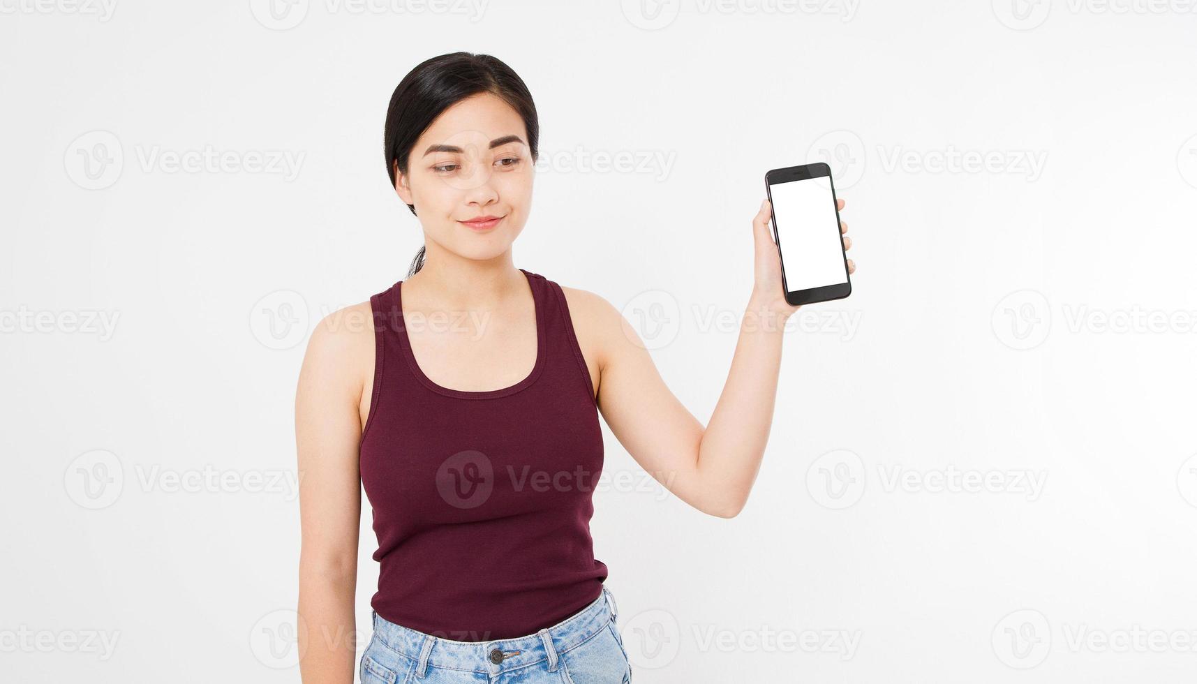 leende asiatisk japansk kvinna håller svart smartphone eller mobiltelefon isolerad på vit bakgrund texture.advertising koncept. positiva ansiktsuttryck mänskliga känslor. kopieringsutrymme. foto