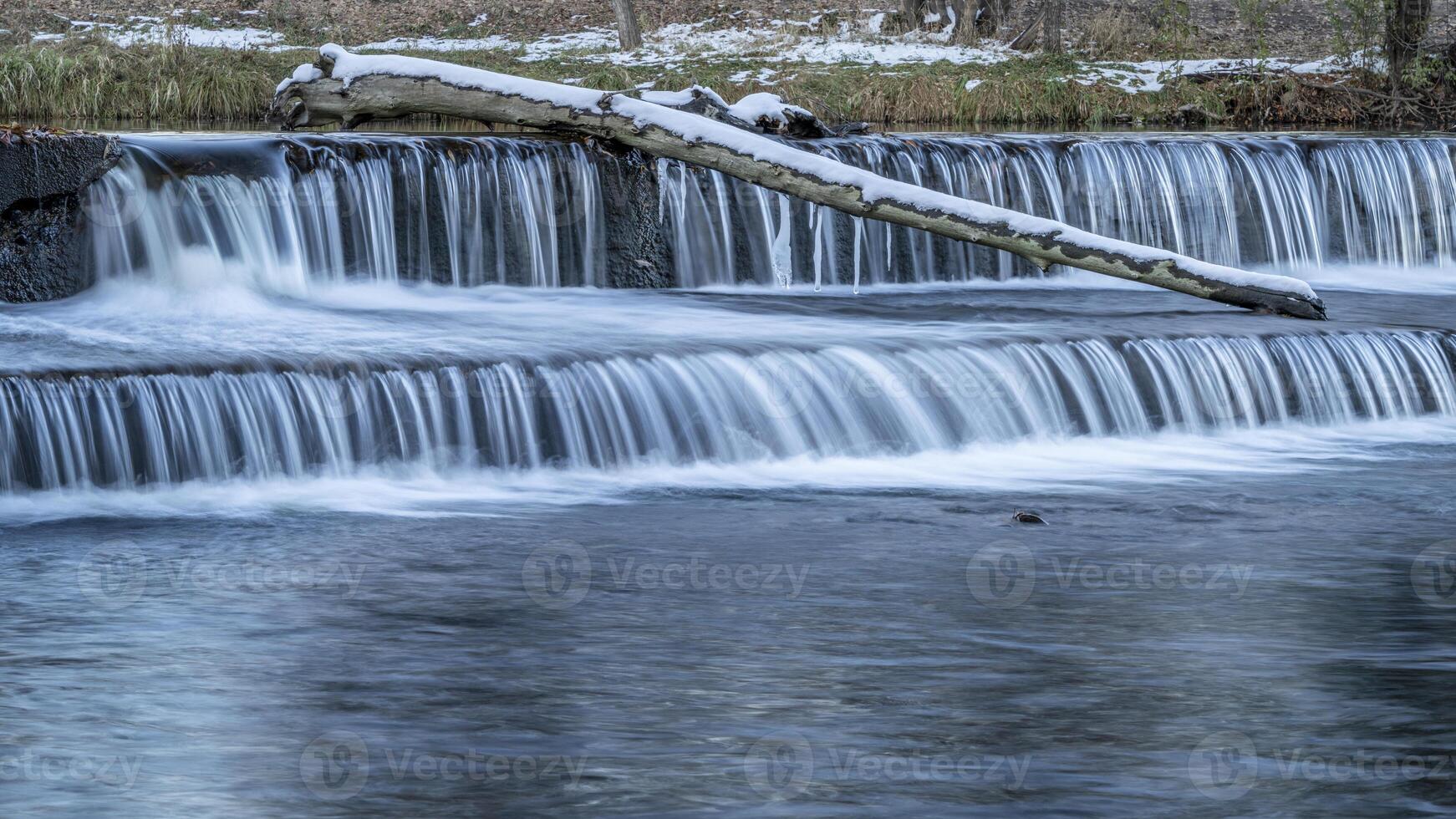 vatten cascading över en avledning damm på de poudre flod med falla landskap i fort collins, colorado, natur och industri begrepp foto