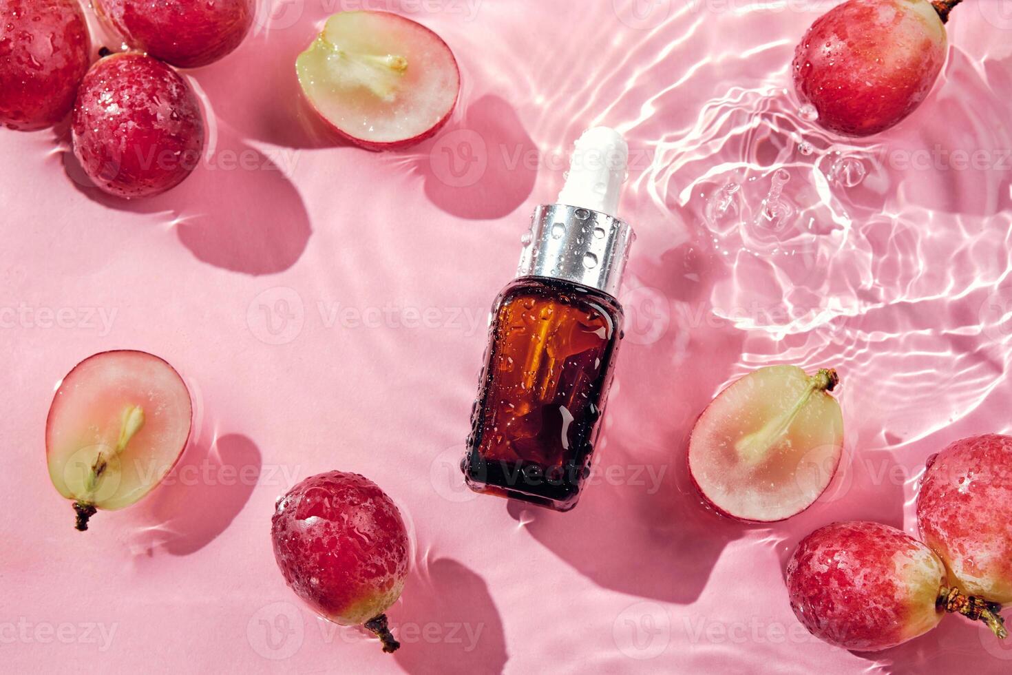 organisk kosmetika med druva utsäde olja och ört- Ingredienser. noll avfall vinframställning. hudvård kosmetisk produkt, vindruvor och vatten stänk på rosa bakgrund foto