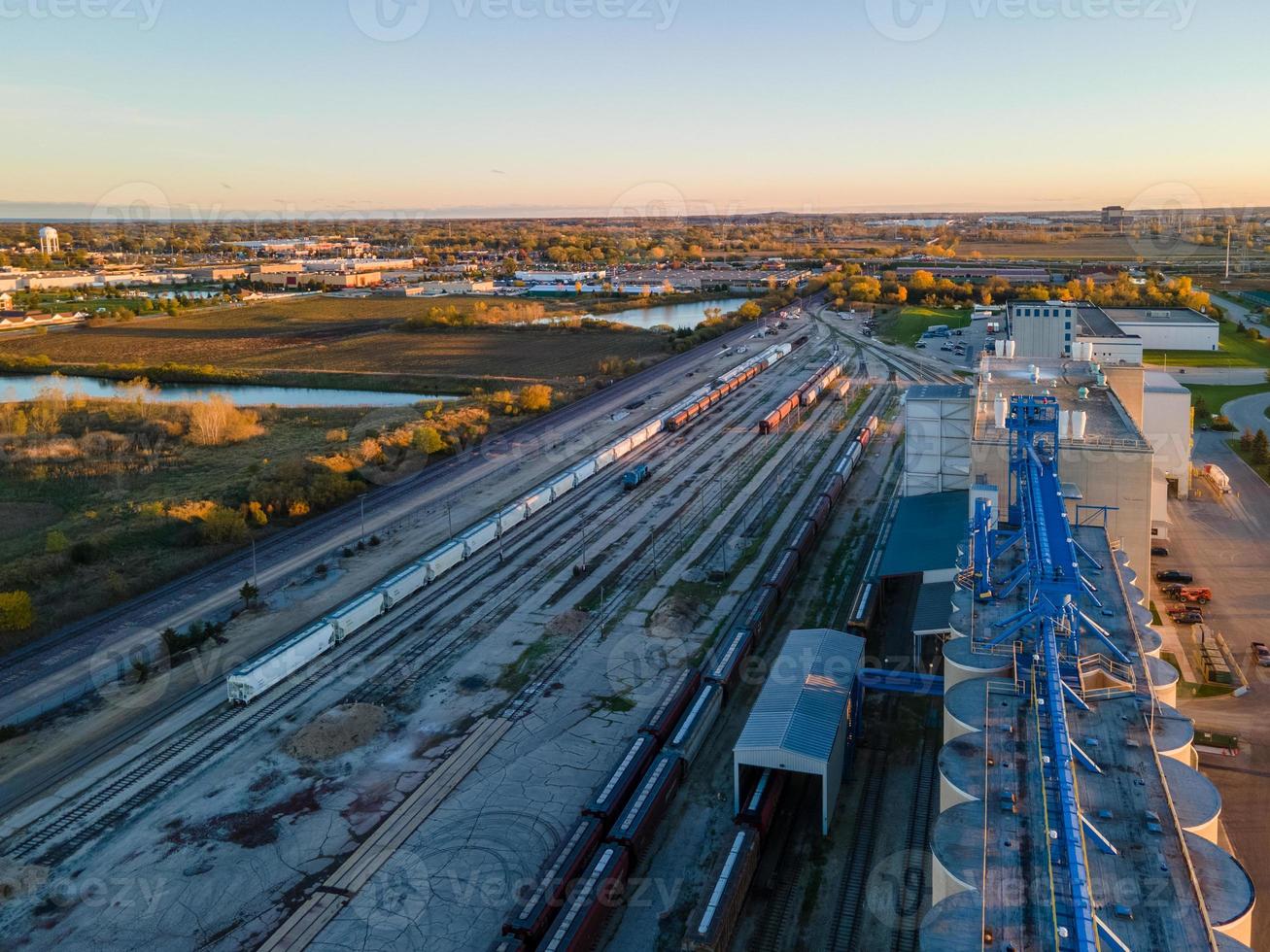 industriell bangård och växelstation i skymningen med urban stad i bakgrunden foto