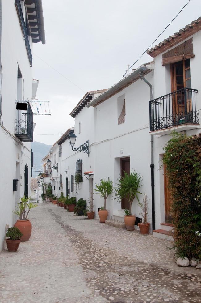 tom gata i altea. vacker medelhavsstad med vita hus och lerkrukor längs gatan. Spanien foto