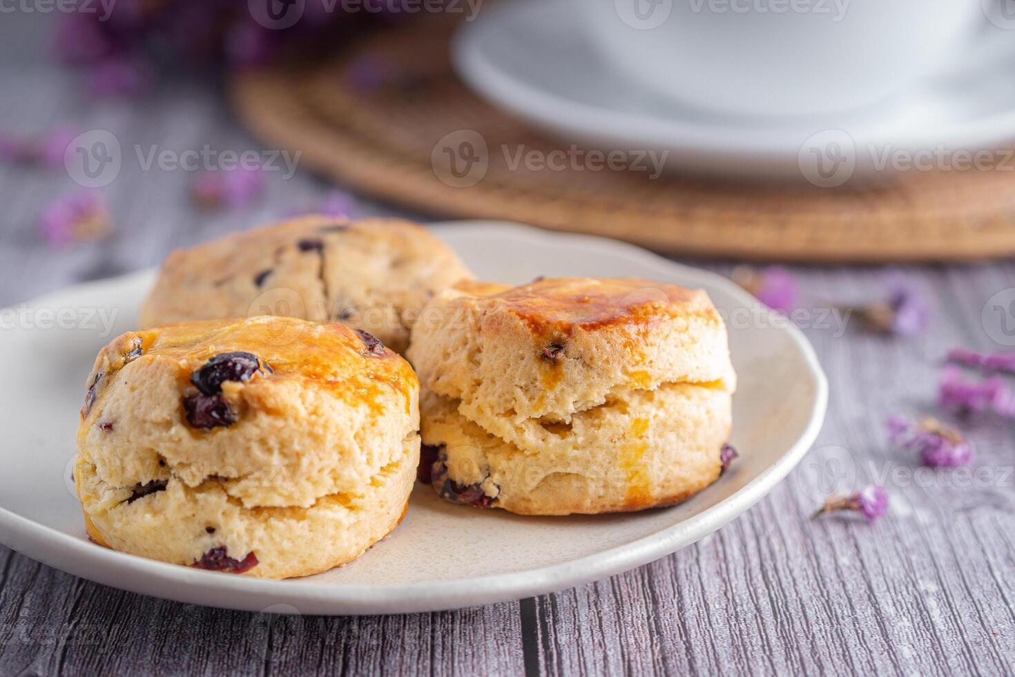 sida se av traditionell brittiskt scones och kaka med en te kopp och suddig bakgrund foto