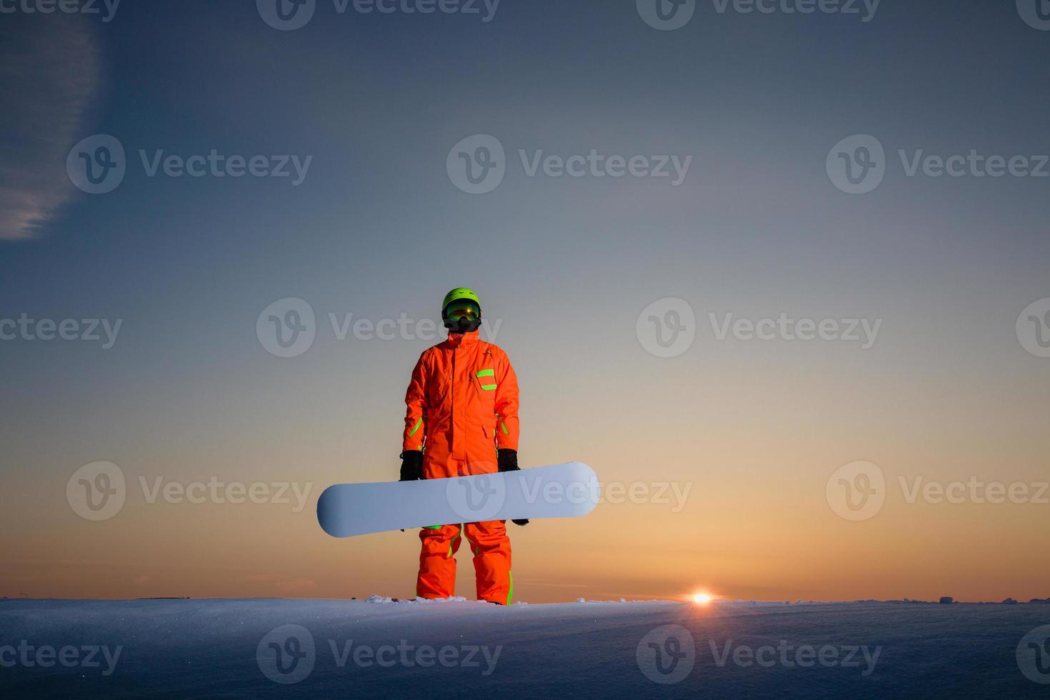 snowboardåkare på toppen av skidbacken i bakgrunden av vacker solnedgång foto