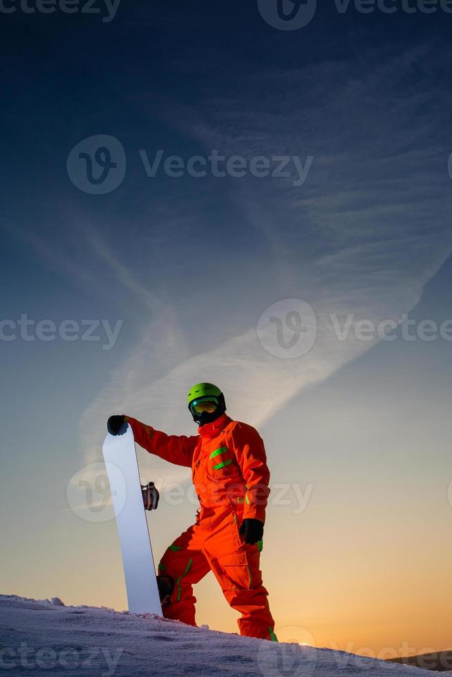 snowboardåkare på toppen av skidbacken i bakgrunden av vacker solnedgång foto