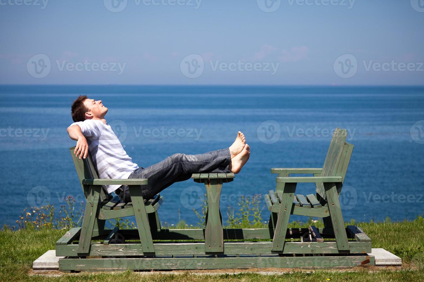 ung man sitter på bänken foto