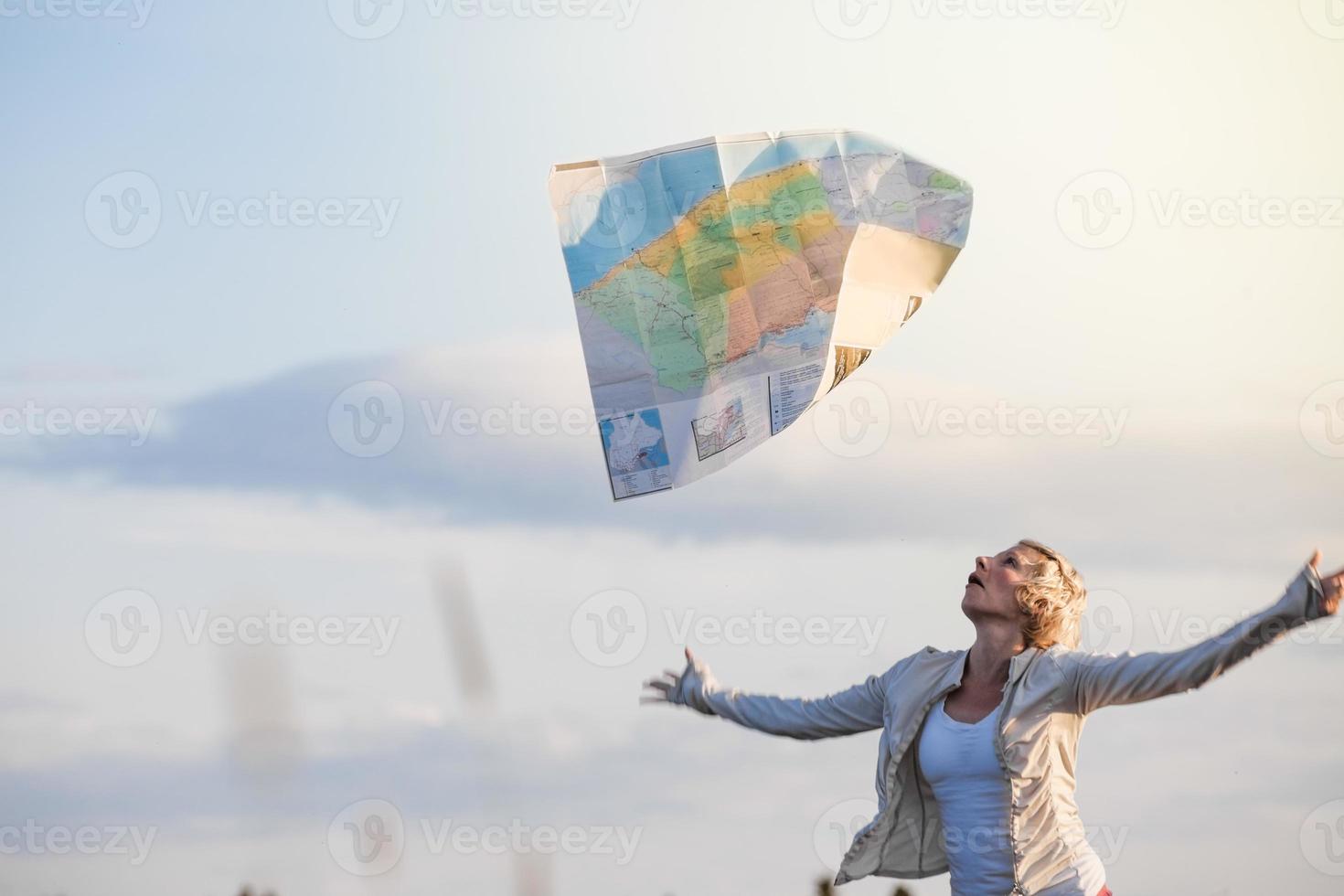 ung förlorad kvinna förlorar en karta på grund av vinden foto