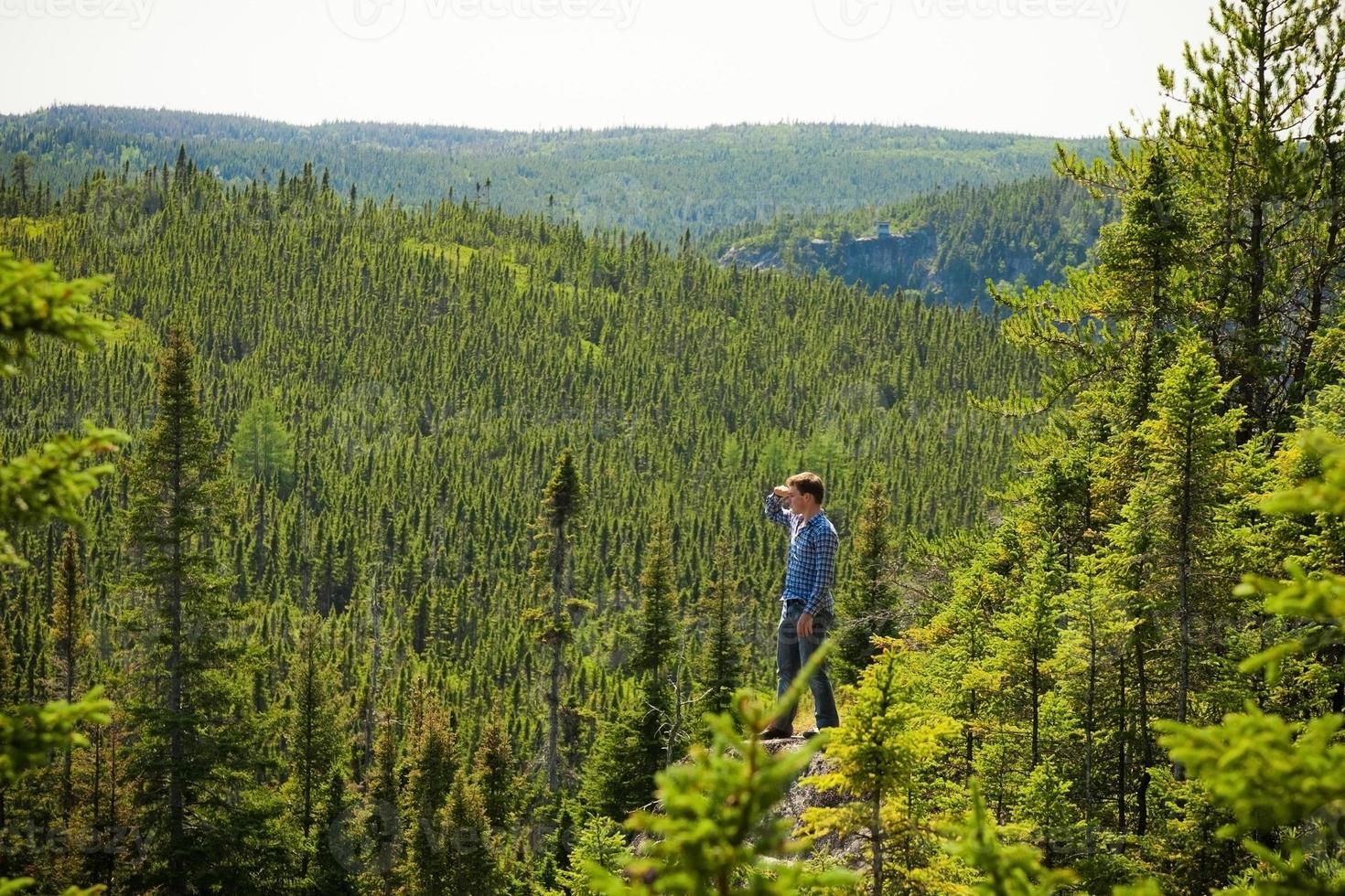 ung man på en sten mitt i naturen foto