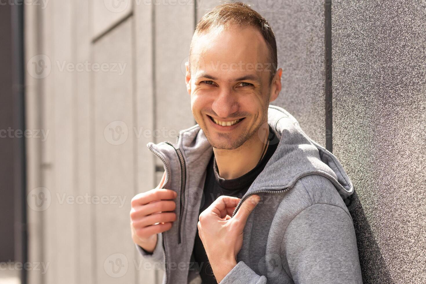 framgångsrik caucasian medelålders man i tillfällig utrusta med vapen korsade isolerat över grå bakgrund foto