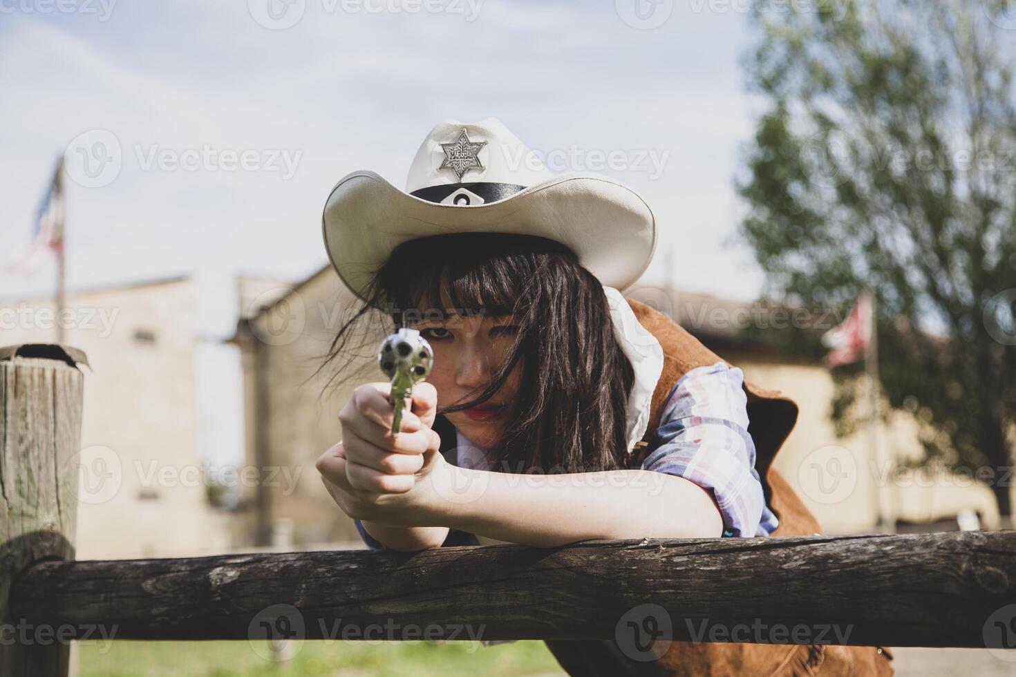 porträtt av en skön kinesisk kvinna cowgirl skytte med en vapen foto