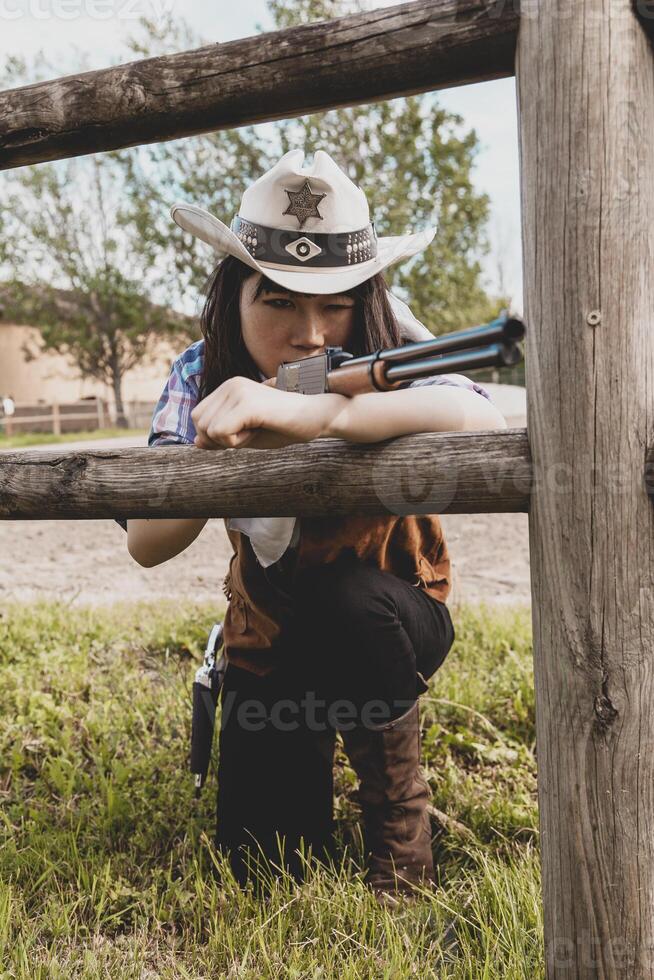 porträtt av en skön kinesisk kvinna cowgirl skytte med en vapen foto