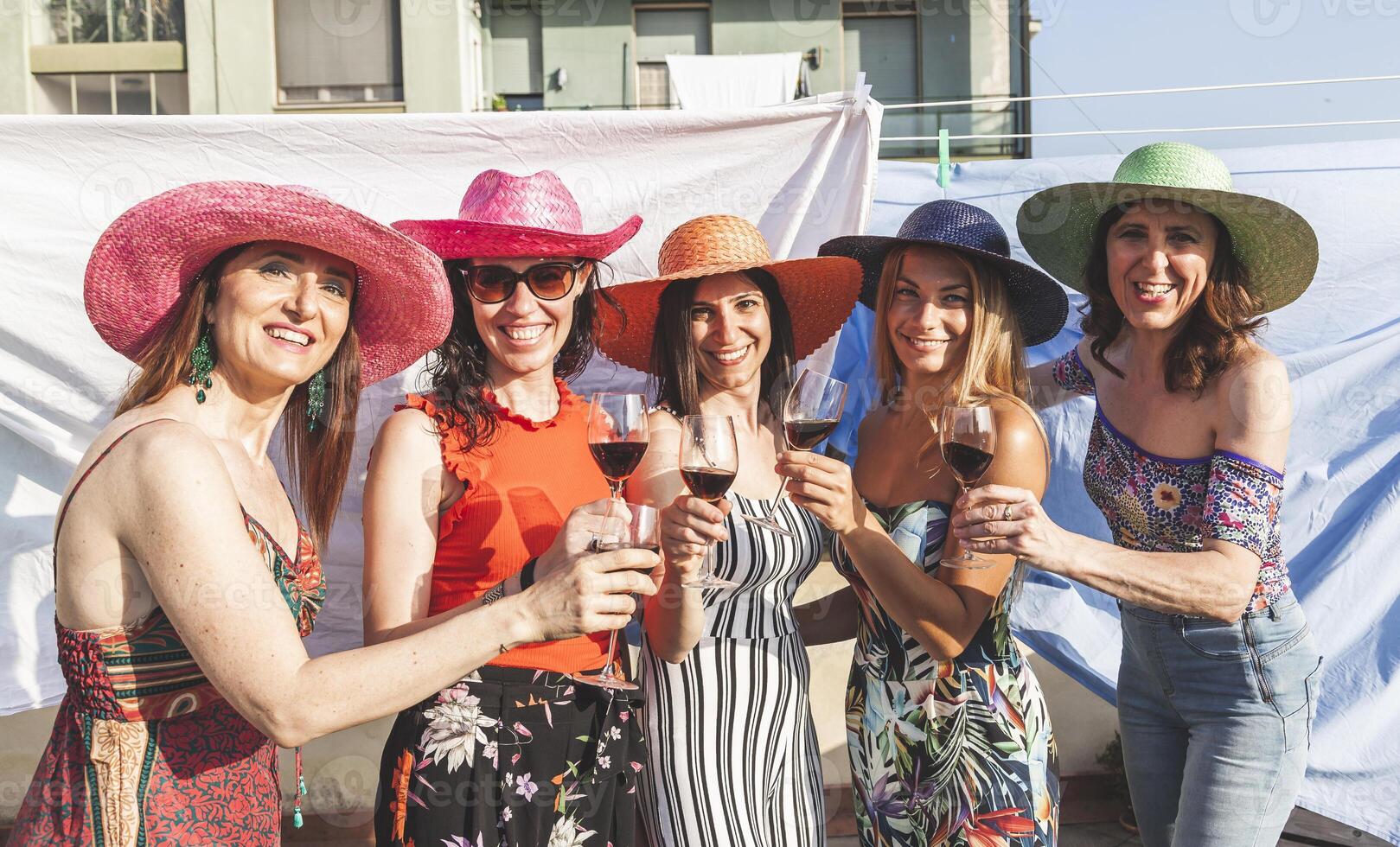 grupp av kvinna vänner bär hattar toasting röd vin foto