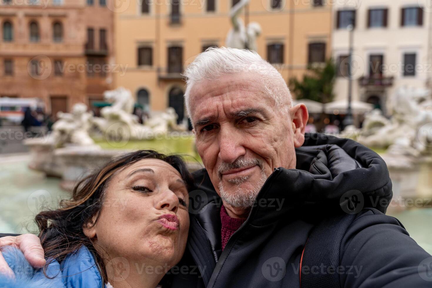 Lycklig mitten åldrig par av turist på semester tar en selfie i främre av en känd navona fyrkant i rom foto