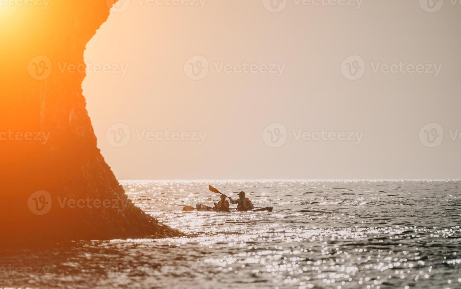 Lycklig par kajaker i ett uppblåsbar kajak på de hav på solnedgång. par kanotpaddling i de hav nära de ö med berg. människor Kajakpaddling i liv jackor segla. tillbaka se foto