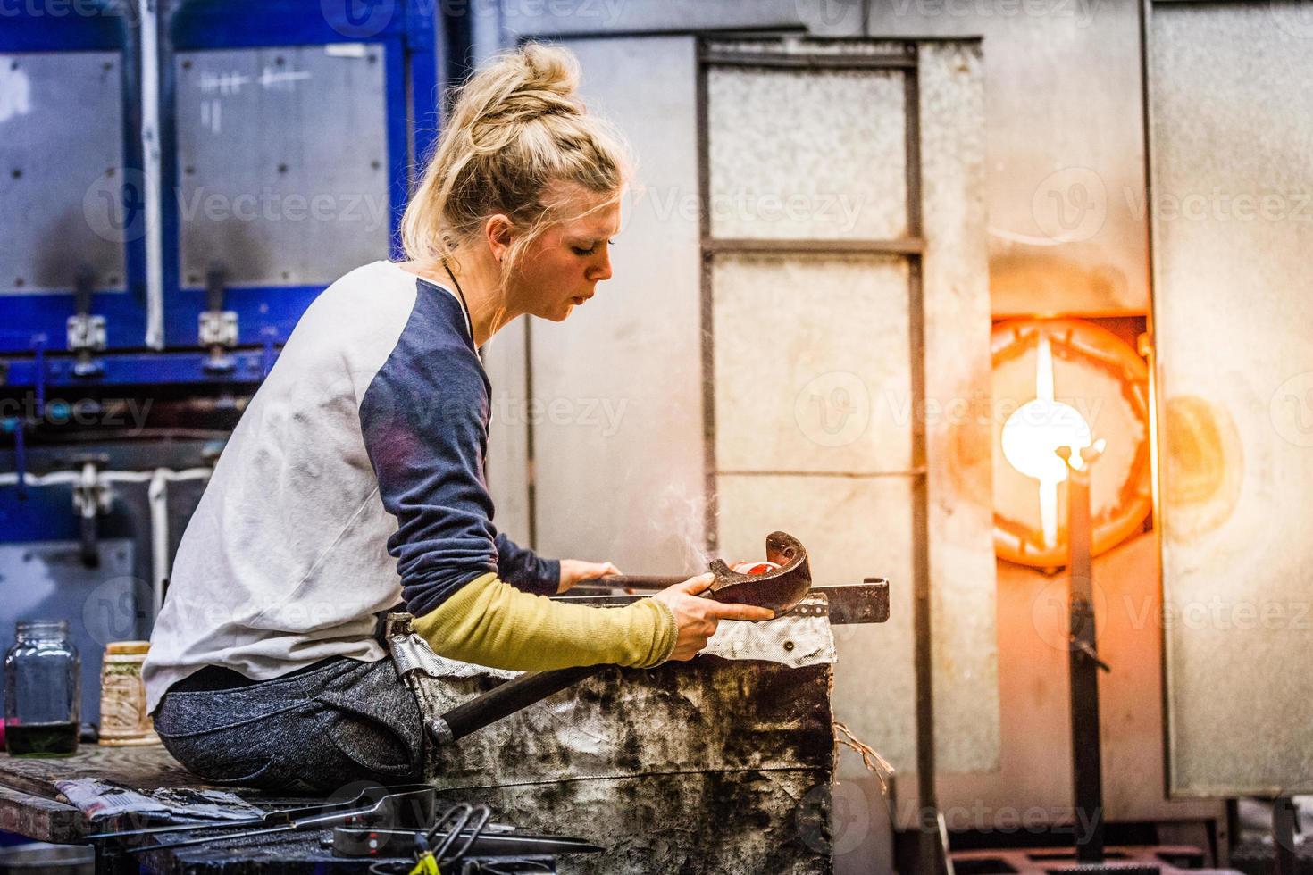 blåser glas professionell kvinna som arbetar på en vas. foto