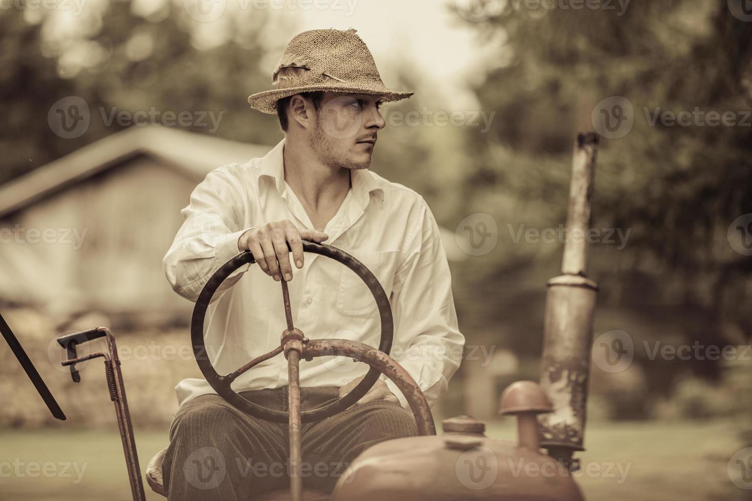 ung bonde på en vintage traktor foto