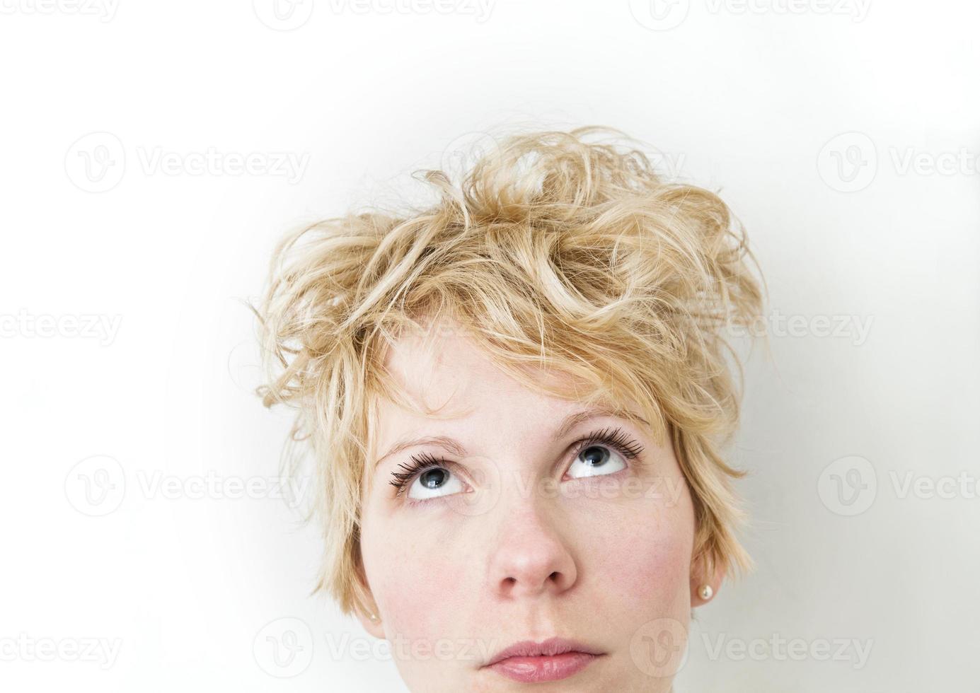 blond flicka tittar upp mycket blandade hårstrån foto
