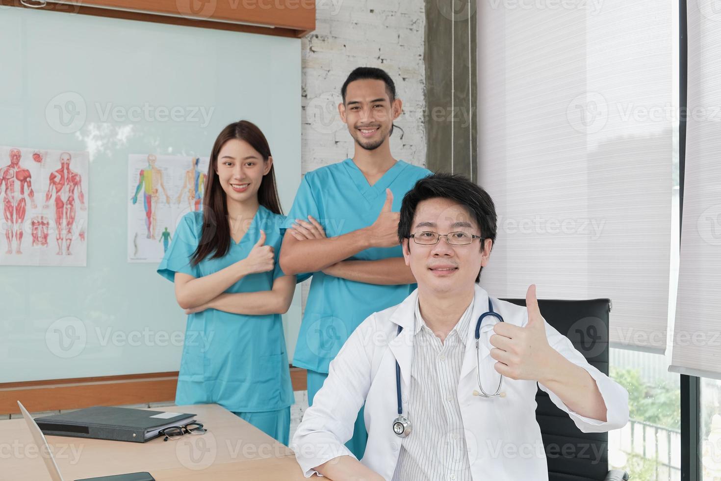 vårdgrupp, porträtt av tre unga läkare av asiatisk etnicitet i uniform med stetoskop, leende och titta på kameran i kliniken, personer som har expertis inom professionell behandling. foto