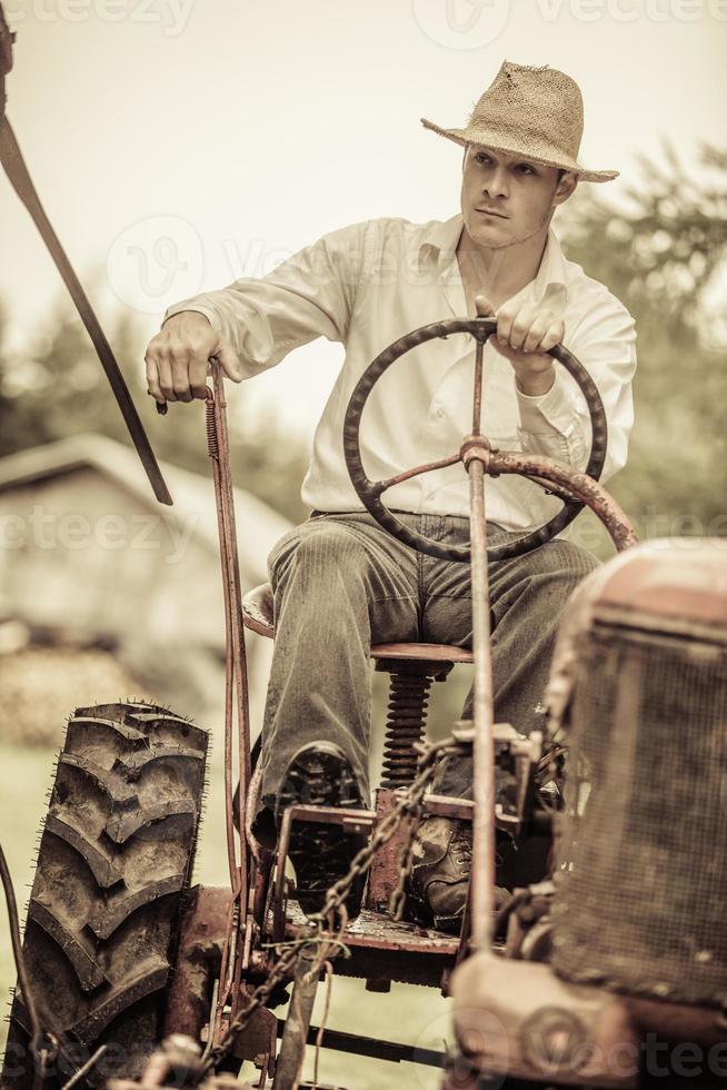 ung bonde på en vintage traktor foto