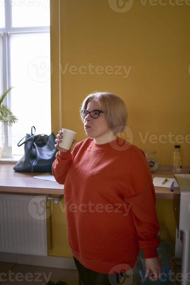 Inaktiverad person dricka kaffe i de kontor kök foto