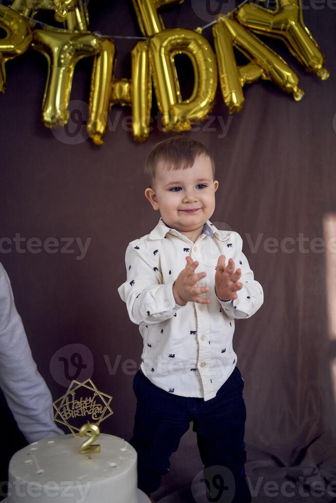 de liten födelsedag pojke klappar hans händer foto