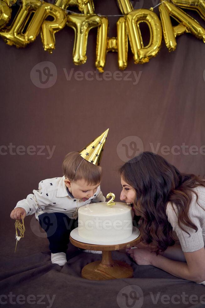 mycket emotionell mamma och henne liten födelsedag pojke äter kaka foto
