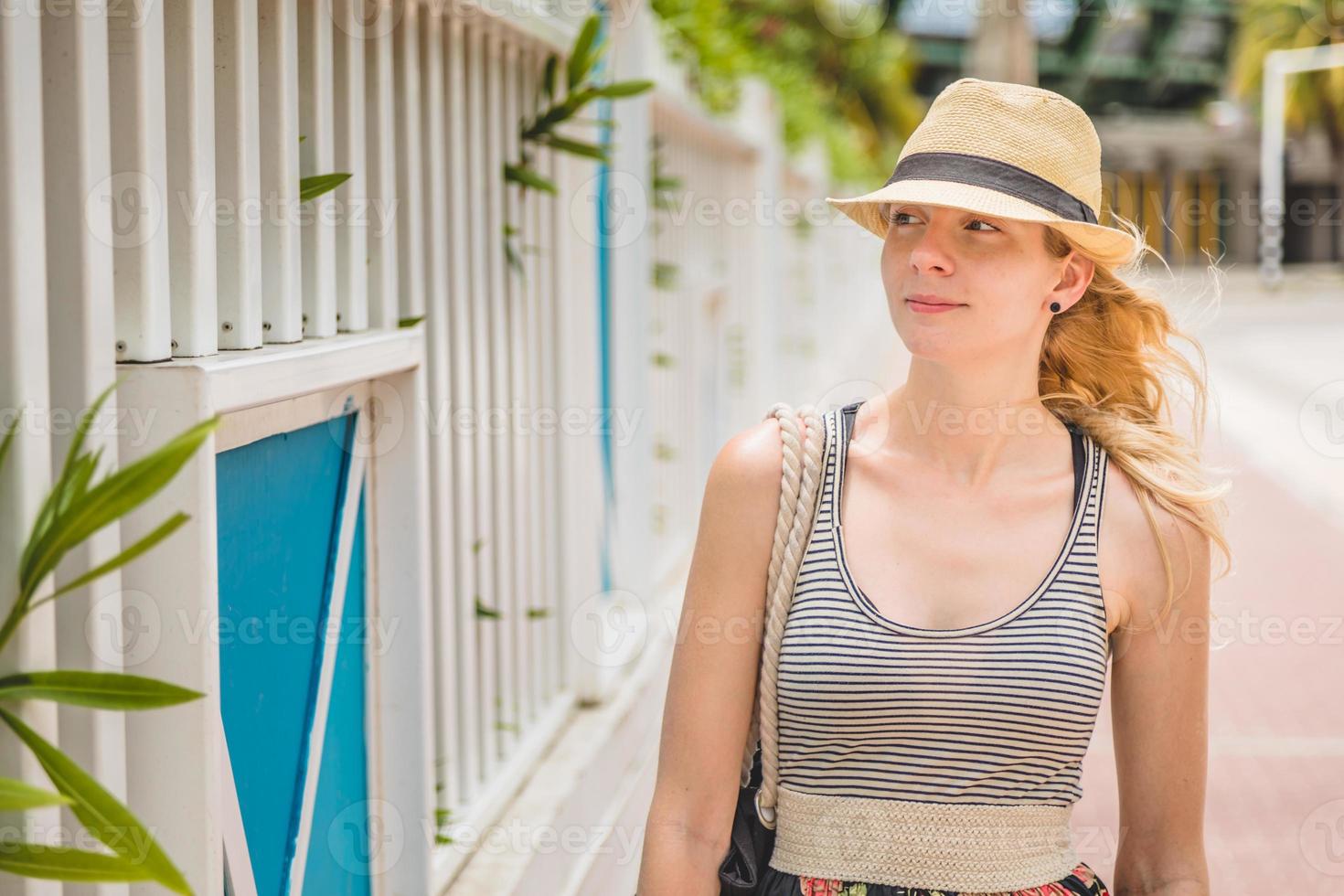 ung blond kvinna i semester promenader på den karibiska gatan foto