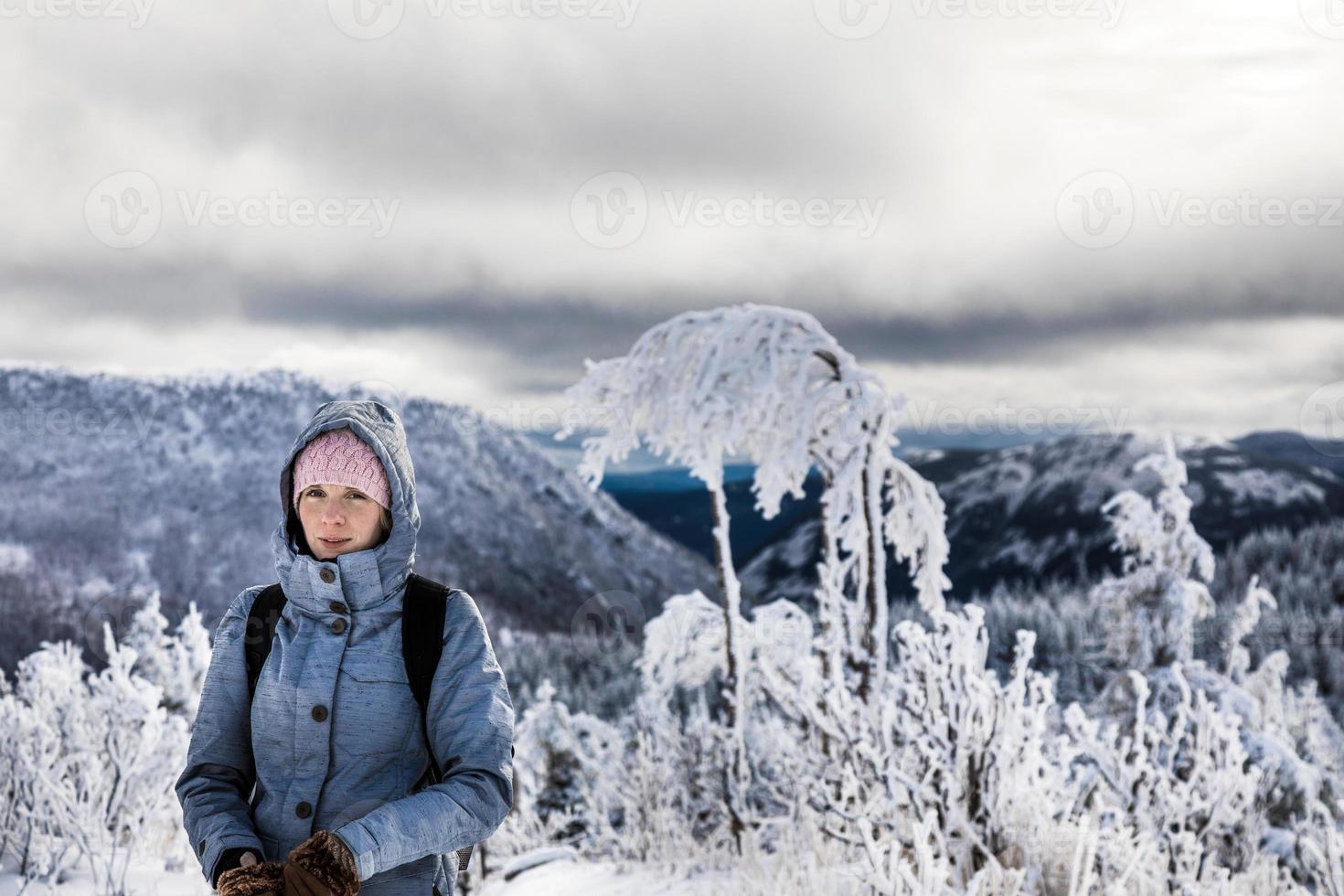 kvinna vandring högt i bergen under vintern foto