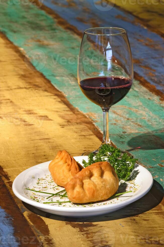 kött empanada, en klassisk av argentine kök åtföljs förbi vin foto