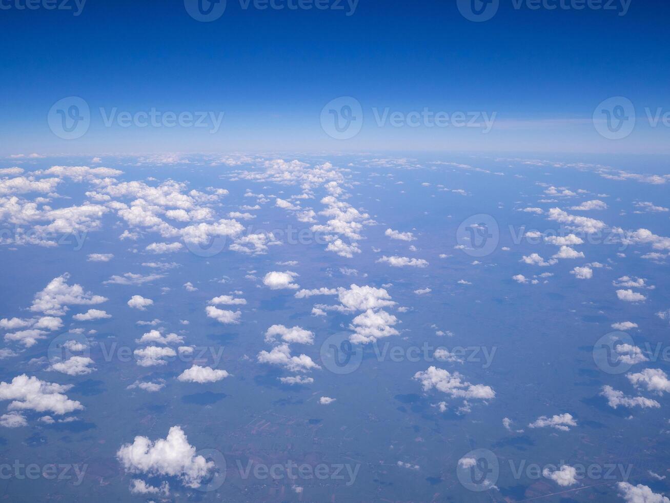 Flygfoto över land och moln sett genom flygplansfönster foto