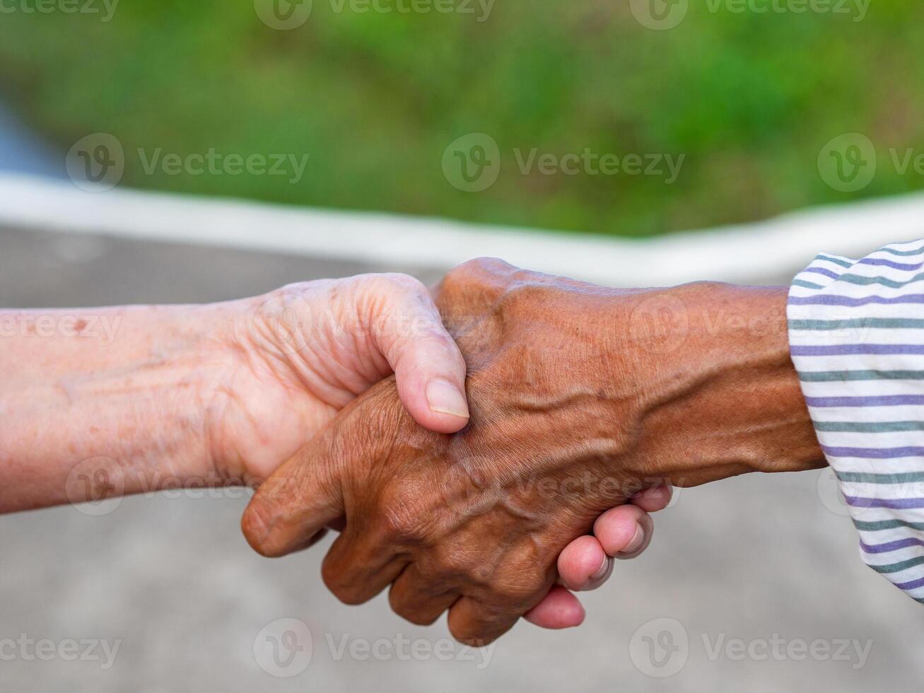 närbild bild av skakning händer mellan äldre kvinnor. enhet begrepp foto