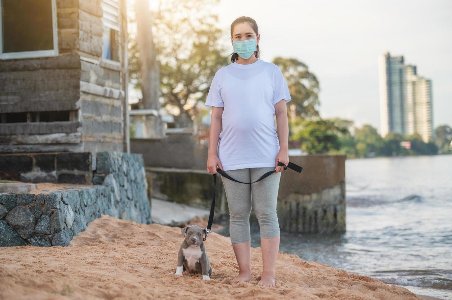 amerikansk översittare valp rolig på stranden med människor familjen resemask ny normal foto