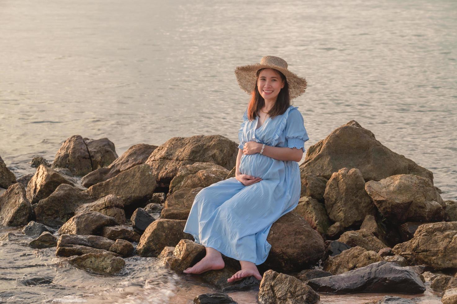 gravid kvinna reser till havet lycklig foto