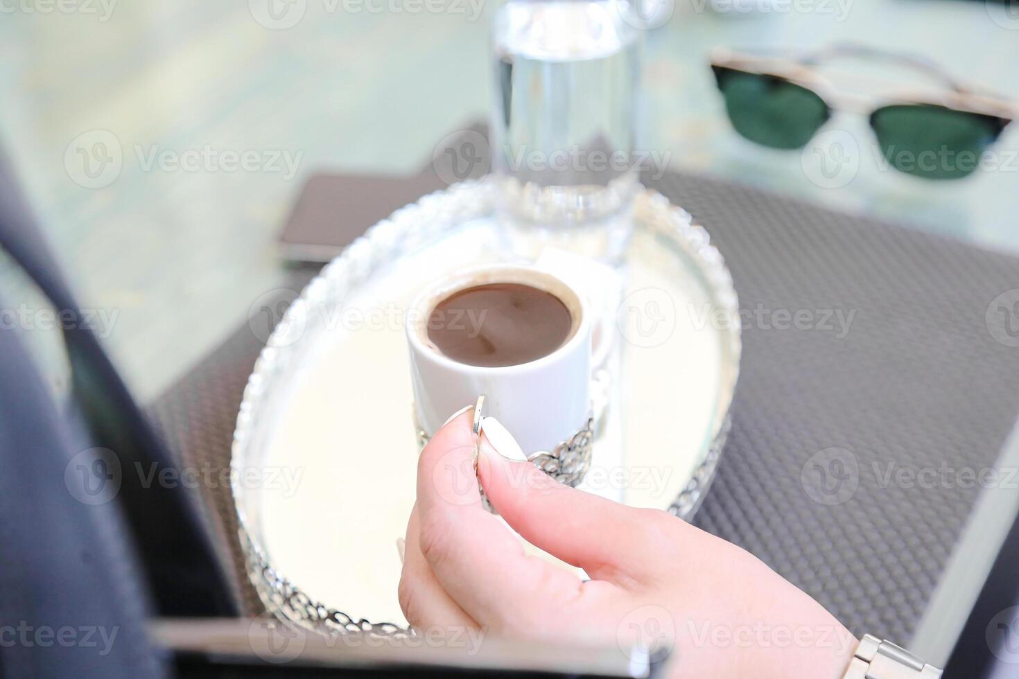 person innehav en kopp av kaffe på bricka foto