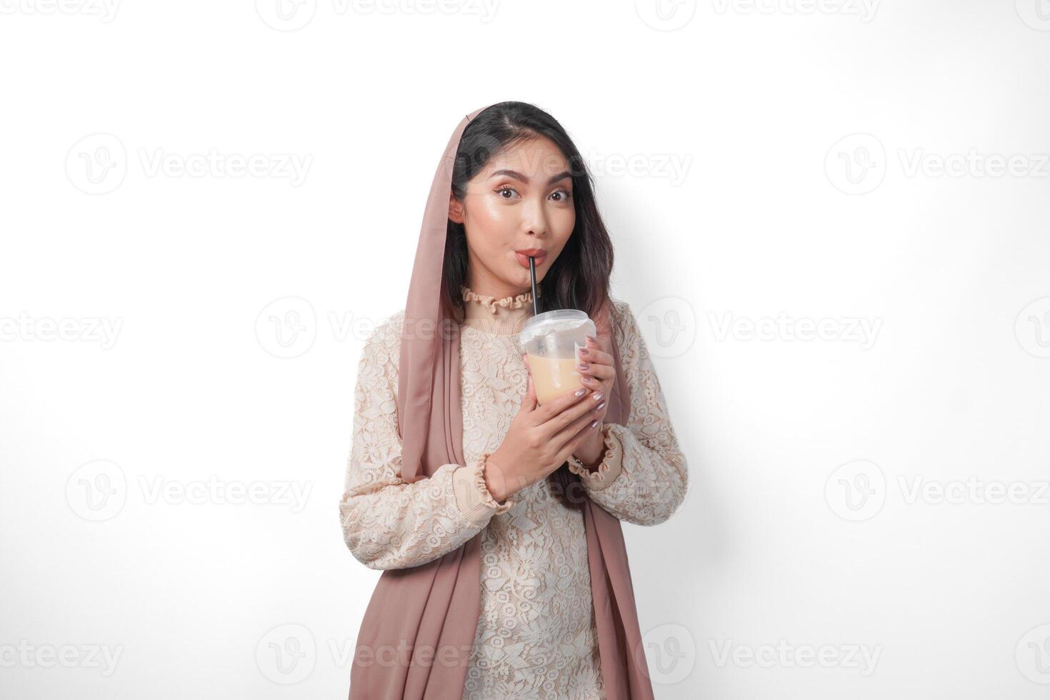 porträtt av asiatisk muslim kvinna i slöja slöja hijab känsla törstig efter fasta och dricka kaffe i en plast kopp. ramadan begrepp foto