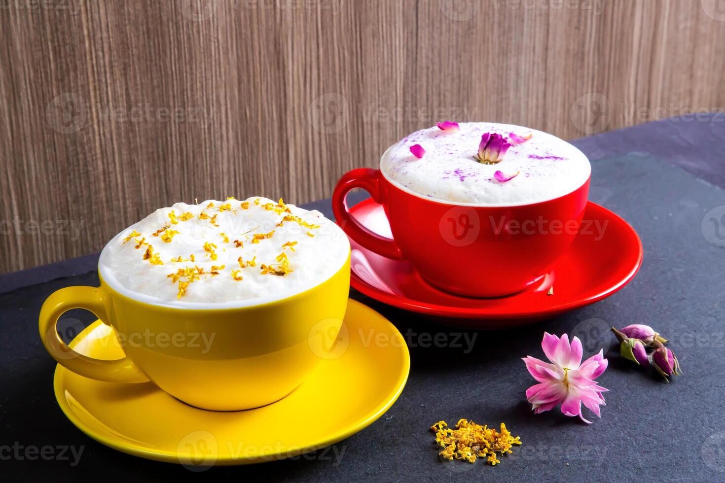 krämig bubbla mjölk te eras i kopp garnering med grädde och blommor isolerat på tabell sida se Kafé efterrätt dryck foto
