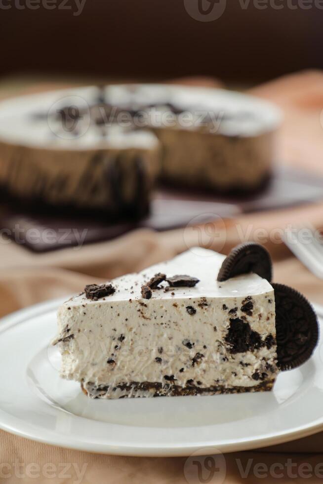 oreo cheesecake skiva inkludera choklad, grädde, socker med gaffel och blommor eras i tallrik isolerat på servett sida se av Kafé mat foto