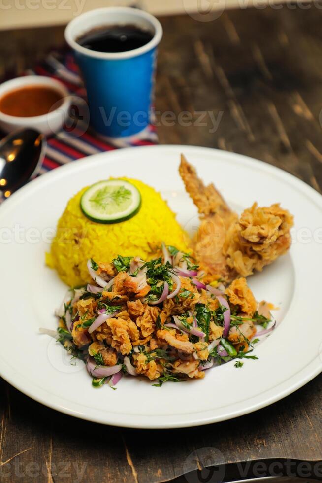varm citron kyckling ris måltid eras i tallrik med sås, kall dryck, sked och gaffel isolerat på trä- styrelse sida se av thai mat foto