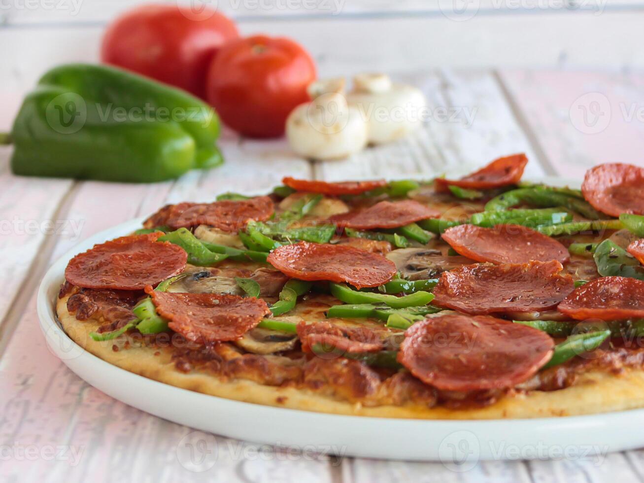 pepperoni pizza garnering med spansk peppar, svamp, tomat och oliver eras i maträtt isolerat på tabell sida se av arabicum snabbmat foto