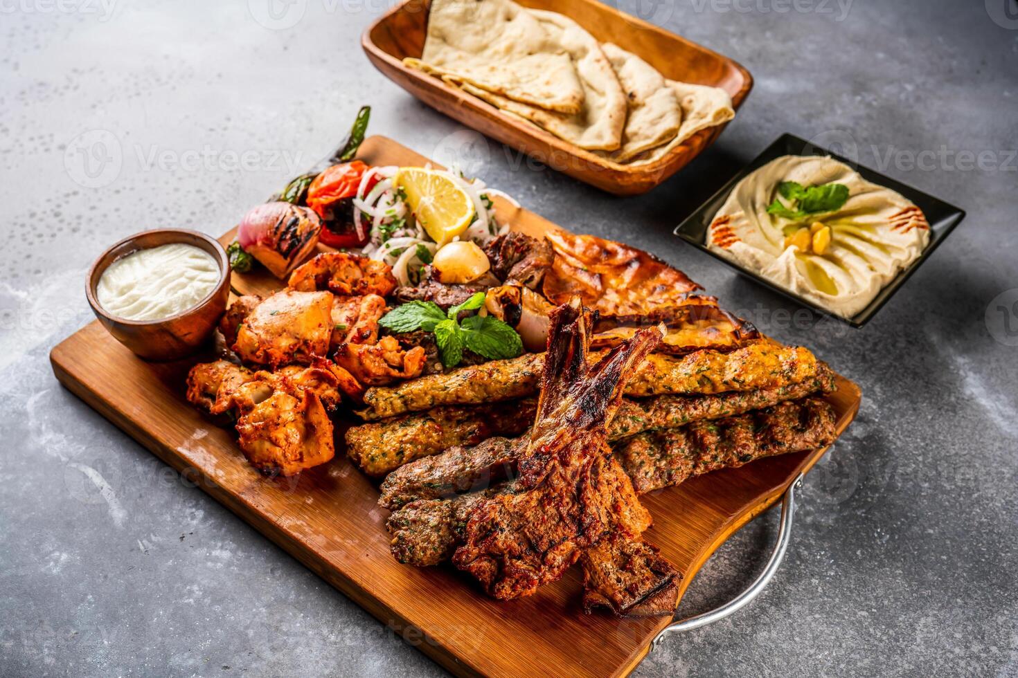 blanda grill med shish tawook, fårkött hacka, mästare, kyckling kabab, nötkött kebab, tikka boti, reshmi och malai, hummus, pita bröd, tandoori roti, raita, sallad och citron- eras i trä- styrelse topp se foto