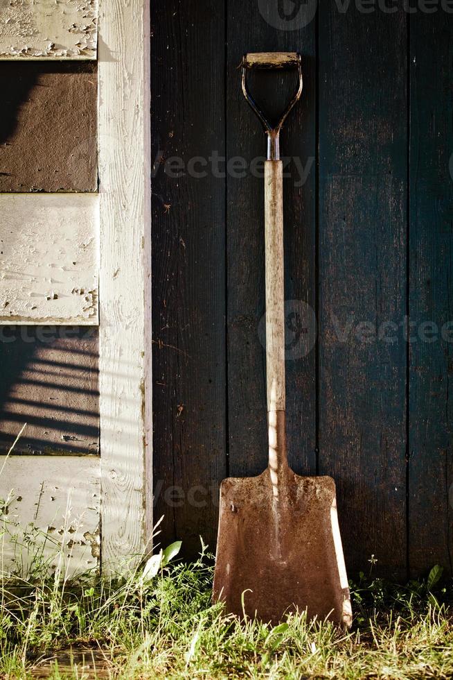 gammal vintage metall spade med rost på blå ladugårdsdörr. foto