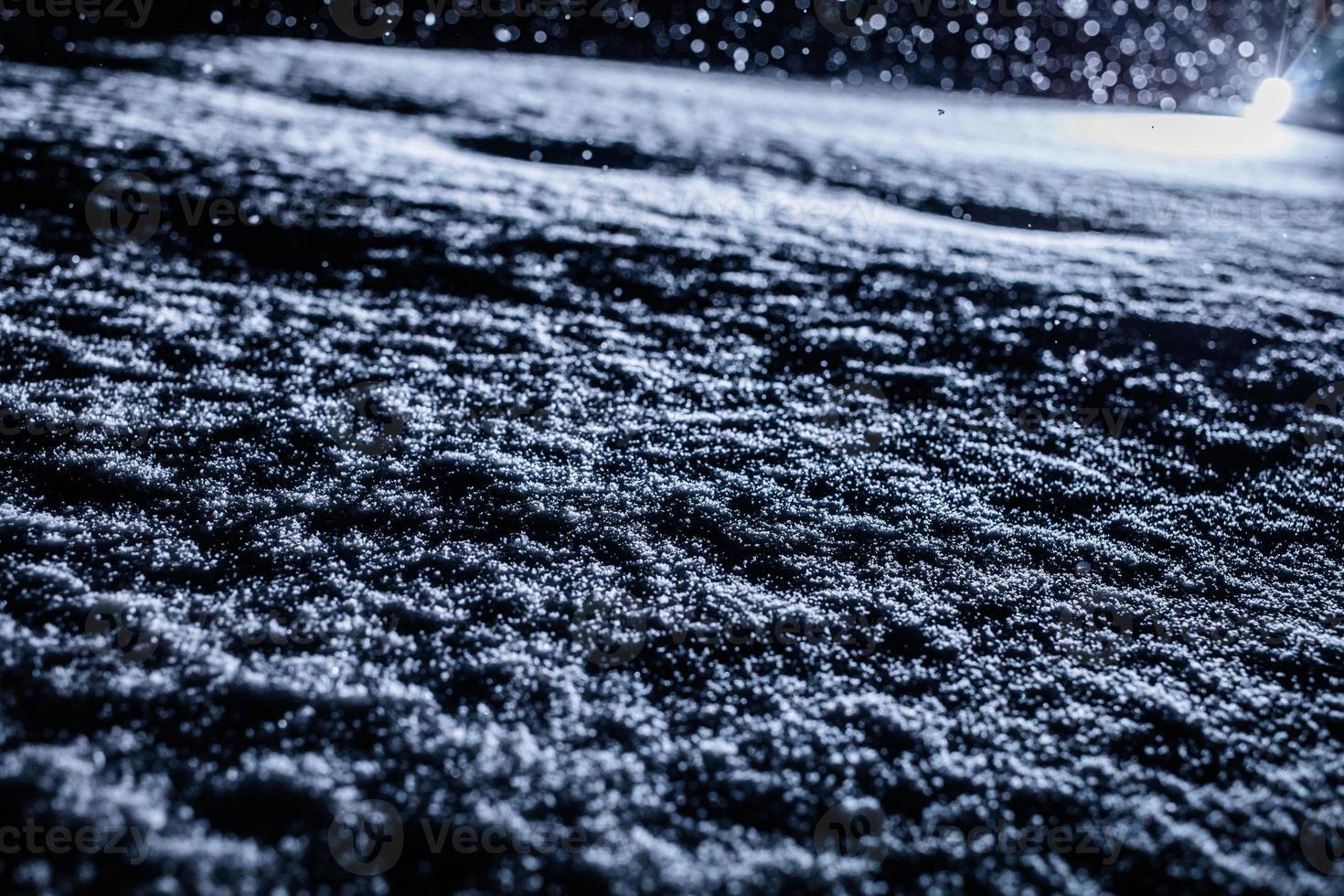 bakgrundsbelyst snöstruktur under snöstorm på natten foto