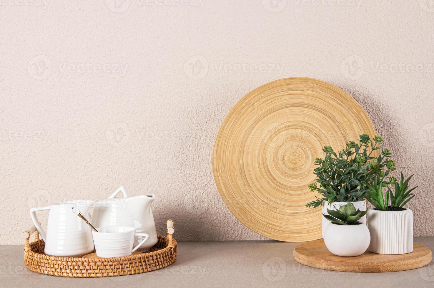 uppsättning av keramisk te fest redskap på en korg- bricka och inlagd krukväxter på en sten bänkskivan av en modern kök. minimalism. foto