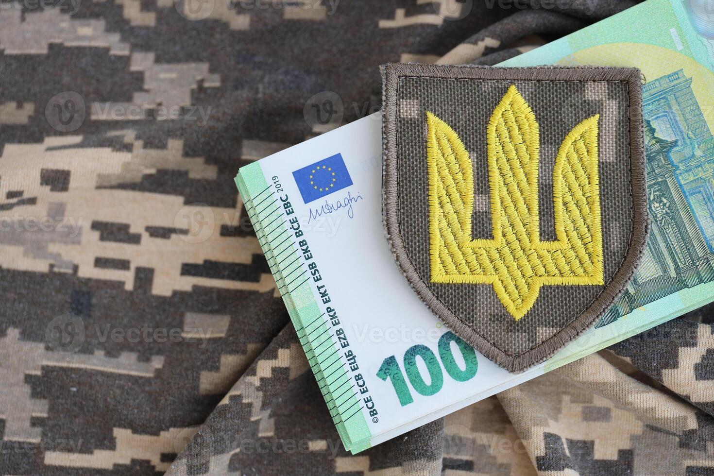 ukrainska armén symbol och knippa av euro räkningar på militär enhetlig. betalningar till soldater av de ukrainska armén från europeisk union, löner till de militär. krig Stöd foto